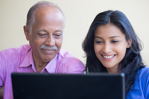 A man and a woman looking at a laptop screen together